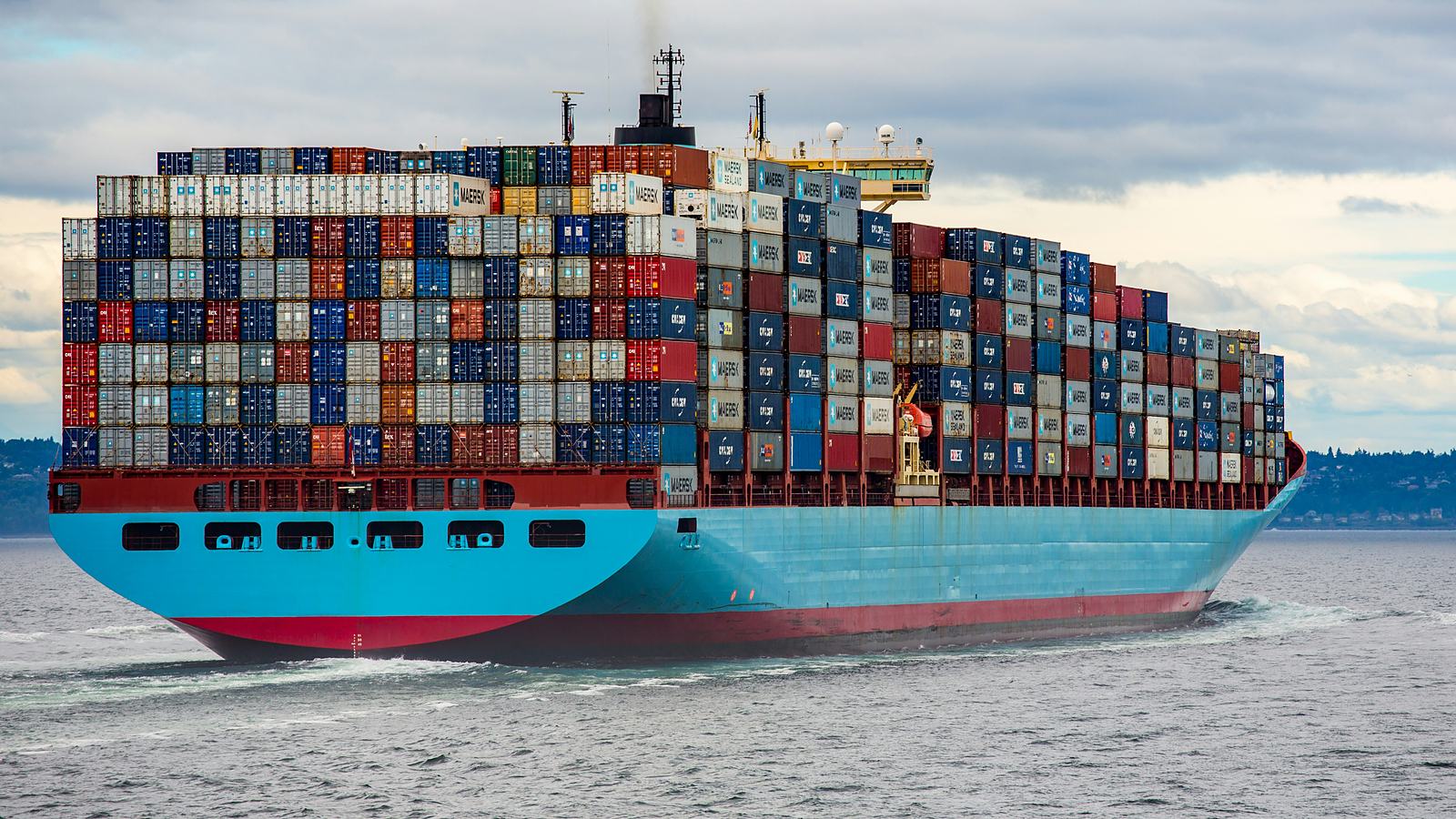 Aerial view of a container terminal with a vessel under tug assistance